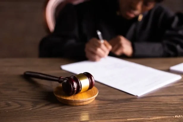 Judge gavel and legal documents on a desk in a courtroom setting