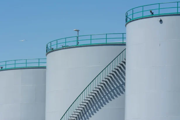 Large industrial aviation fuel storage tanks at an airport facility