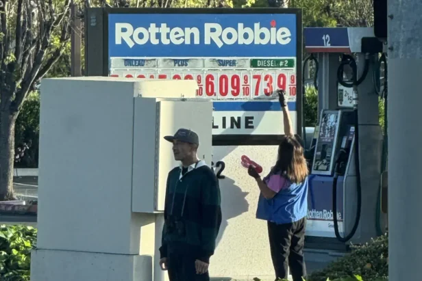 A gas station price sign displays fuel costs exceeding $10 per gallon as drivers face unprecedented price increases at the pu