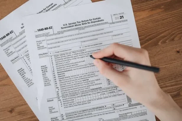 A person holds documents and a smartphone, illustrating how scammers can quickly register fraudulent companies using stolen i